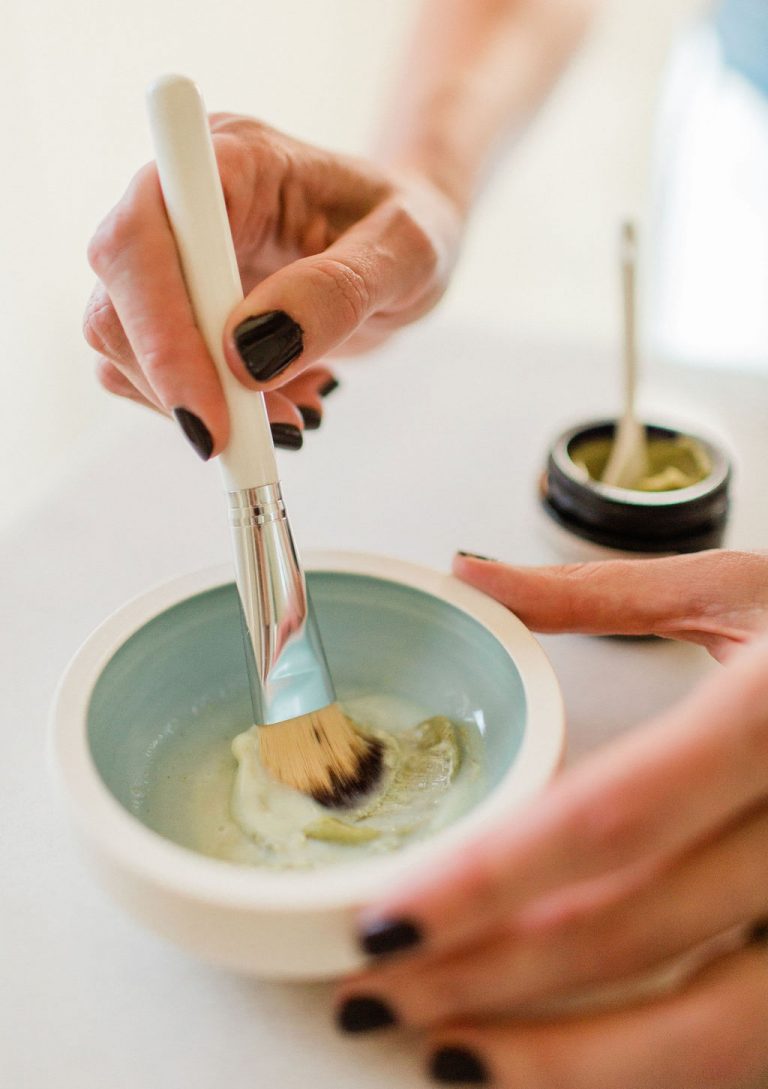 Mixing up a green beauty mask in a mask bowl