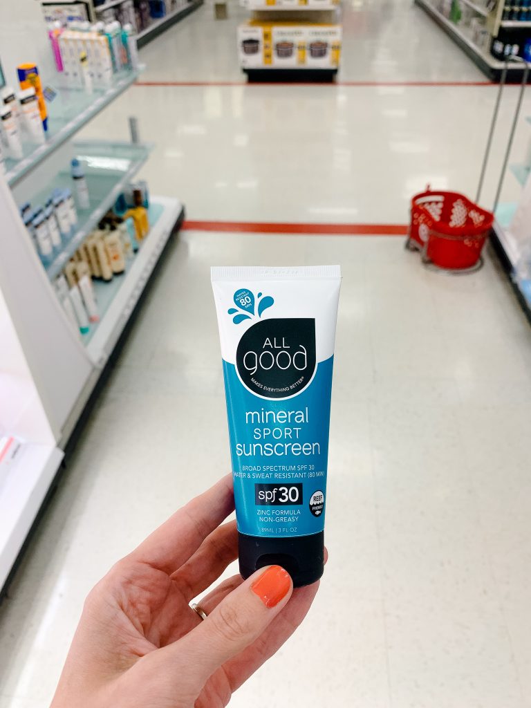 Holding up a natural sunscreen at Target